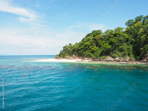 Island in the blue sea with white sky and clouds.