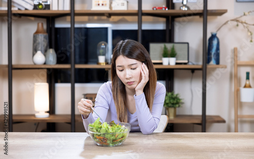 Asian beautiful woman are bored of eating vegetable salad  Women don t want to eat vegetables.