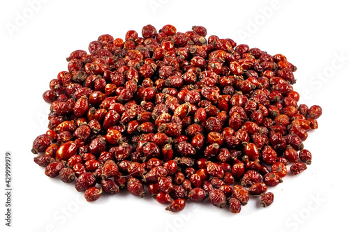 Dried rose hips isolated on white background. Pile of dried rose hips. Dried medicinal herbs raw materials isolated on white. Dogrose or Rosa canina hips.