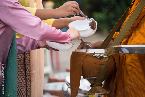 Mon offer food to monk begging bowl, Sangkhlaburi