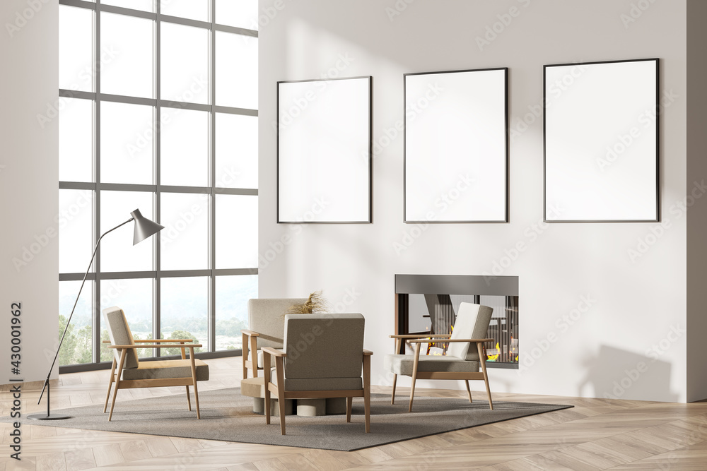 Contemporary white living room interior with fireplace, armchairs. Three posters in a row template mockup on wall. Big panoramic window. Contemporary white living room interior with fireplace, armchairs. Three posters in a row template mockup on wall. Big panoramic window.