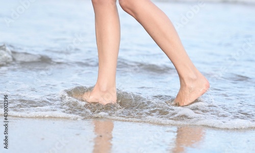 the feet of a woman walking on the beach