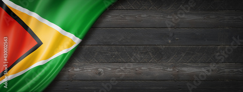 Guyanese flag on black wood wall banner