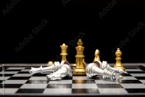 Фотография golden king and queen knight and bishop is last standing in the chess board conc
