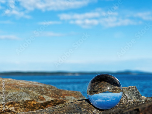 Spectacular rocky shore of Sidney BC with beautiful skies reflects in the lens ball © pr2is