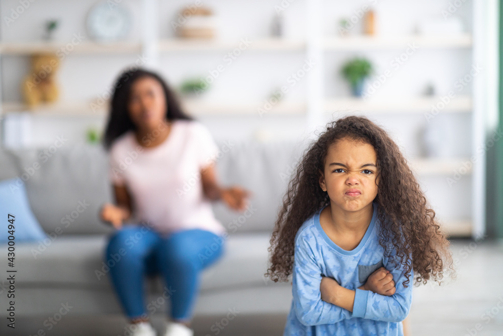 Little black girl feeling angry, taking offence at her mother at home, copy  space. Parent child conflict concept Stock Photo | Adobe Stock