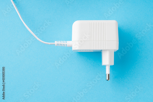 white power supply unit of an electrical appliance, top view on a blue background