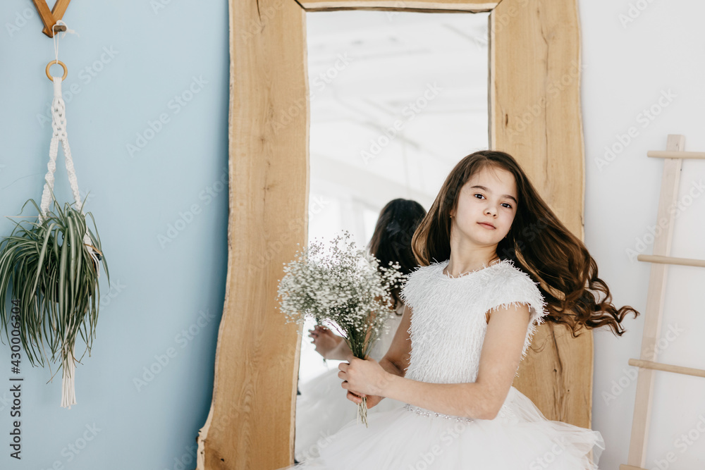 preteen flower girl in white dress with a bouquet of white gypsophila ...