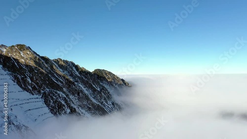 Flying over clouds and Fagaras mountains. Transfagarasan road in winter.