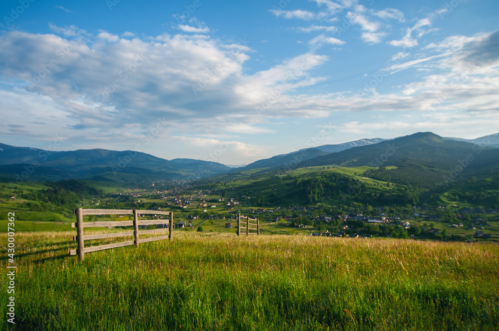 amazing view with high mountain village on horizon and blue cloudy sky. summer landscape. beautiful natural background