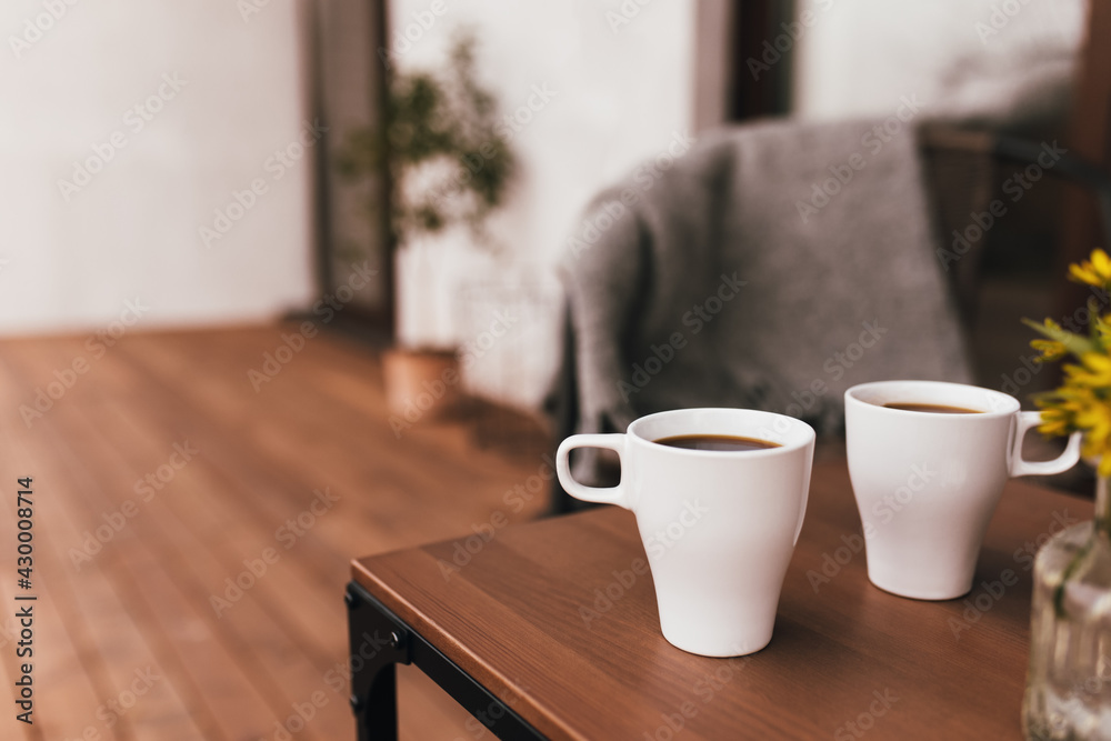 Fototapeta premium Two cups of coffee on the table on wooden brown terrace during evening sunset