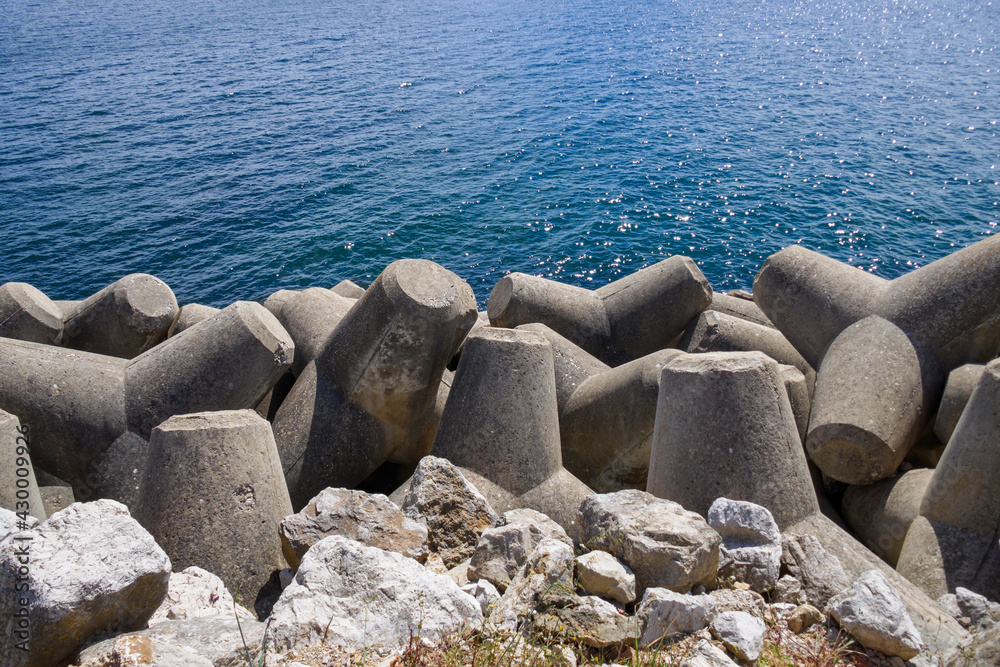 Concrete tetrapodes breakwater. Costal erosion protection pier Concrete tetrapodes breakwater. Costal erosion protection pier