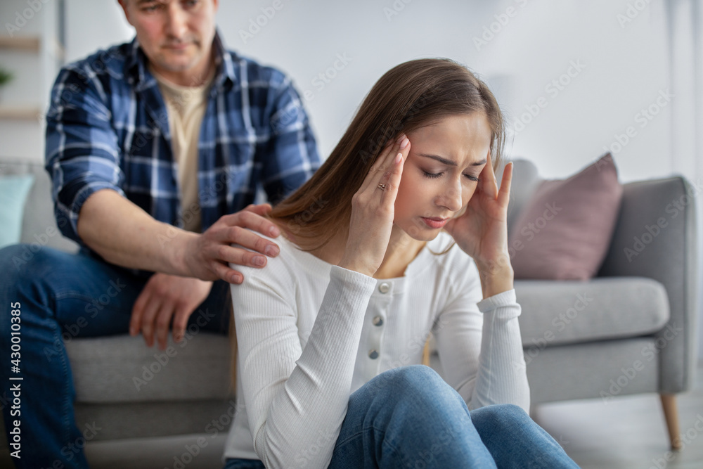 Middle-aged woman feeling stressed, facing health issues, having problem, her husband supporting her at home Middle-aged woman feeling stressed, facing health issues, having problem, her husband supporting her at home