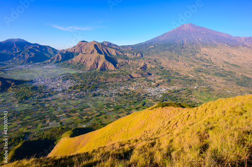 Crop fields view at sunrise from Sembalun viewpoint, overlooking Mt. Rinjani on the right