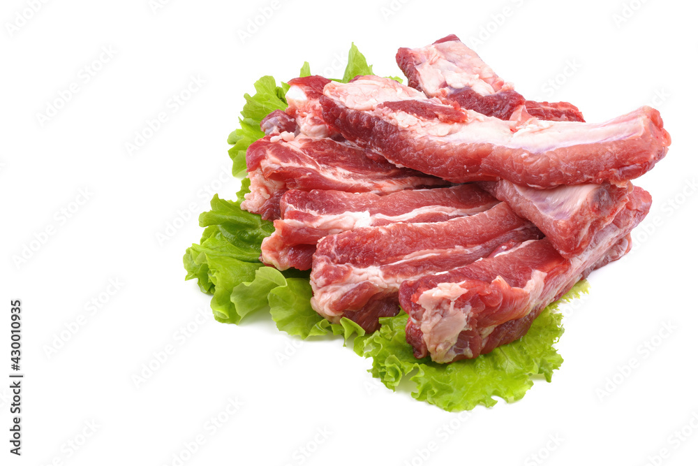 Sliced pork ribs on a lettuce leaf are isolated on a white background.Preparation of meat dishes.