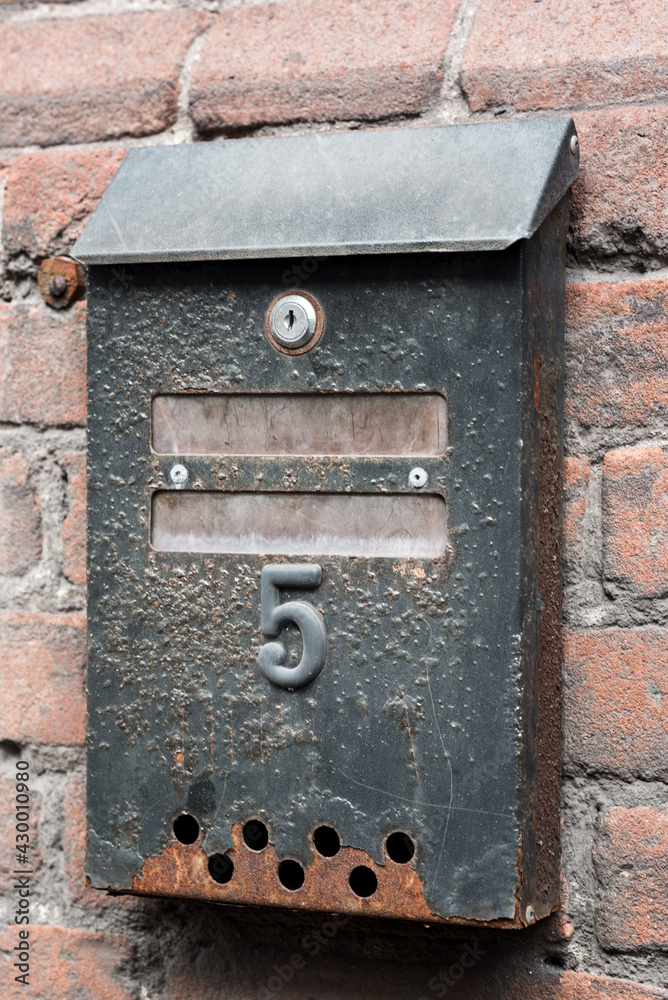 old rusty letterbox with number five