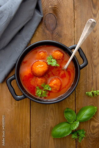 Meatballs with tomato sauce on wooden background, delicious mediteranean food