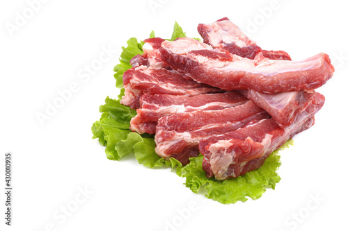 Sliced pork ribs on a lettuce leaf are isolated on a white background.Preparation of meat dishes.
