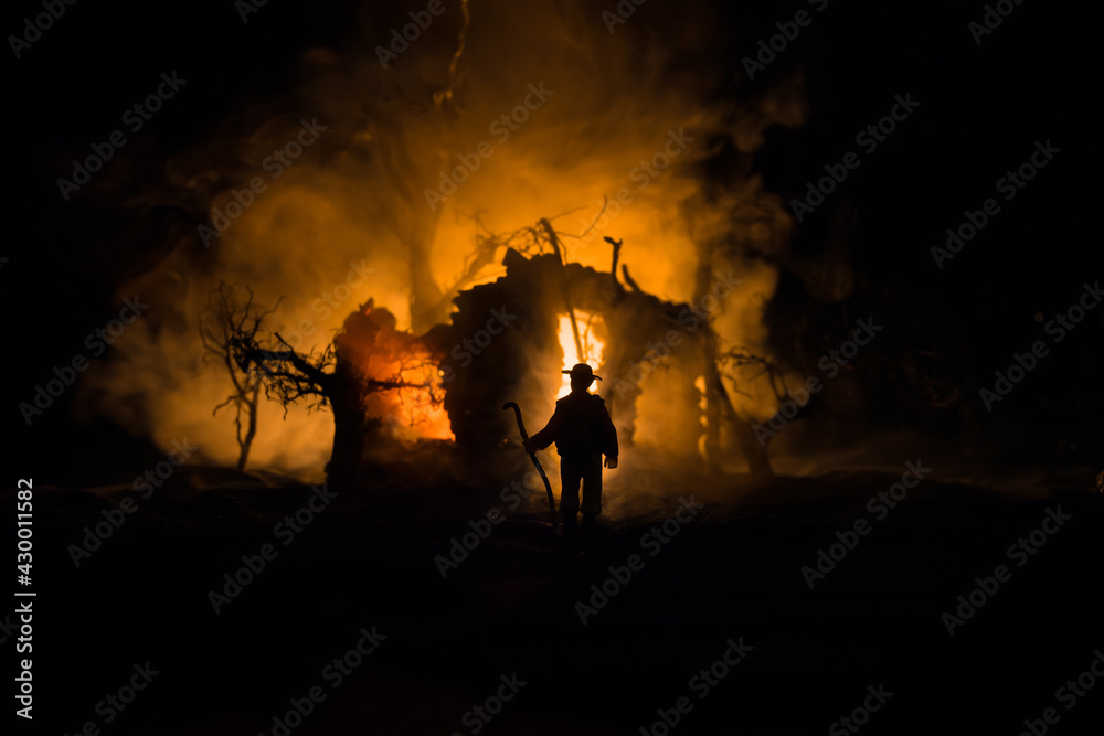 Fototapeta premium Old stone house burning uncontrollable in the night. A fire in a country house. Creative artwork decoration.