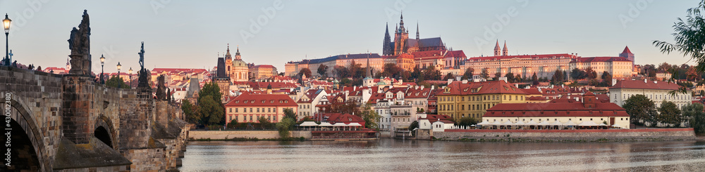 Banner, Prague riverside, Charles Bridge and castle at dawn. Romantic Prague at dawn. Vltava riverside on sunrise, with St. Vitus cathedral and castle towers forming skyline behind