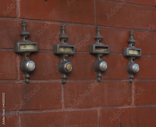 Vintage doorbells on a brick wall.