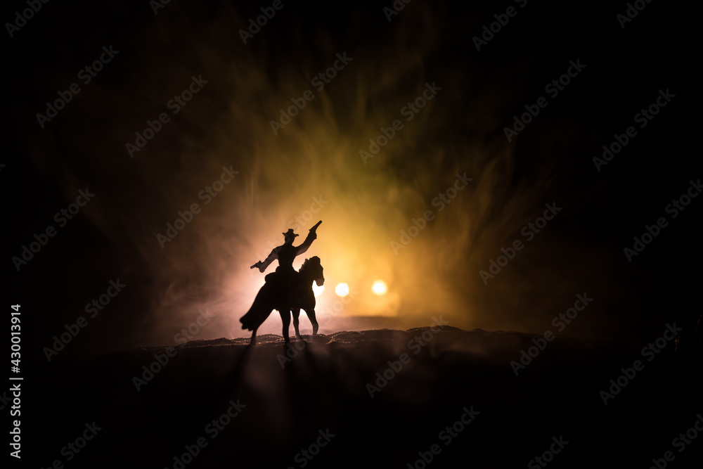 Fototapeta premium Western cowboy silhouette with texture at sunset and slivers of light