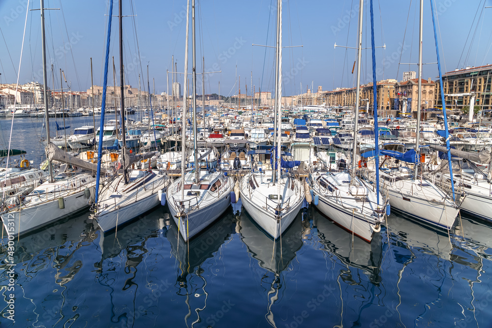 White yachts reflected in still water in the Old Port of Marseille, France. Front view.