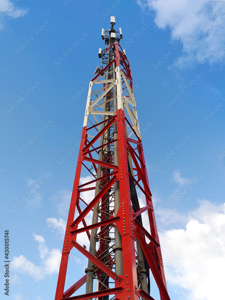 Bottom view of telecommunications tower under Caribbean blue sky. Metallic structure and antennas for broadcasting and transmission of short wave signals. Telephone repeater close up. Communications. Bottom view of telecommunications tower under Caribbean blue sky. Metallic structure and antennas for broadcasting and transmission of short wave signals. Telephone repeater close up. Communications.