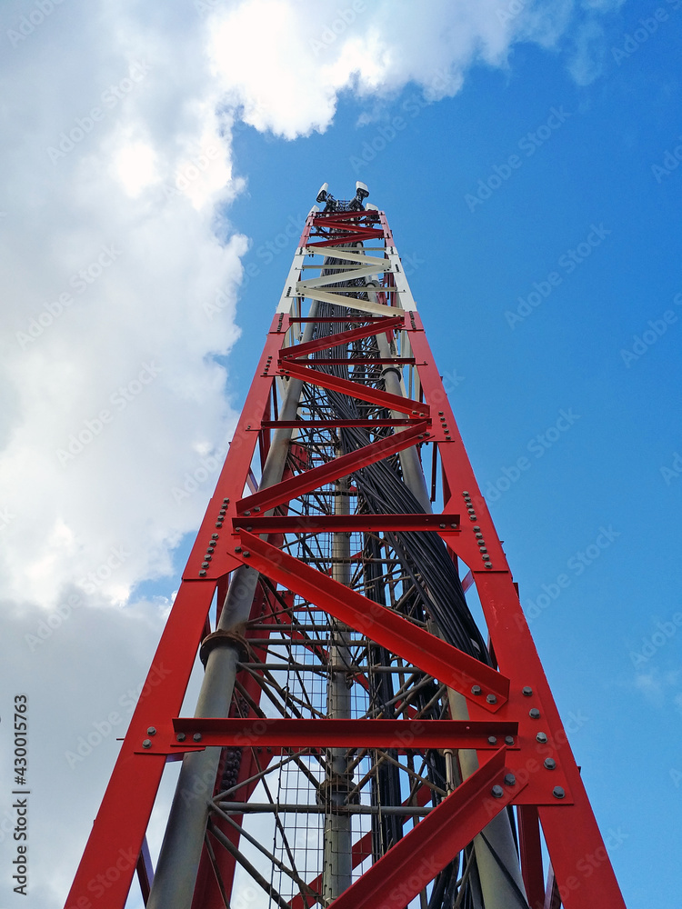 Bottom view of telecommunications tower under Caribbean blue sky. Metallic structure and antennas for broadcasting and transmission of short wave signals. Telephone repeater close up. Communications. Bottom view of telecommunications tower under Caribbean blue sky. Metallic structure and antennas for broadcasting and transmission of short wave signals. Telephone repeater close up. Communications.