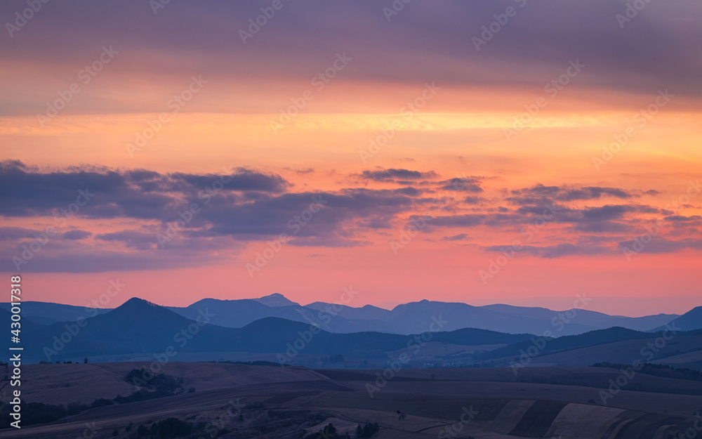 Mountain rural landscape with colored clouds on a sky during a sunset. Rajecka valley in the north of Slovakia, Europe.