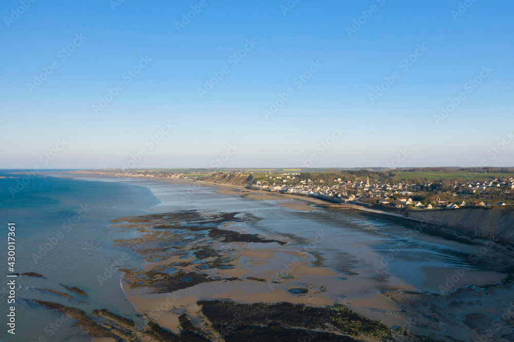 Le port artificiel de Arromanches sur la plage de Gold beach et la ville en France, en Normandie, dans le Calvados, au bord de la Manche sous le Soleil.
