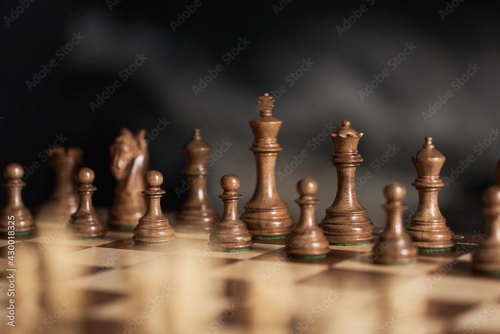 real chess pieces on a dark background made of quality boxwood wood. The beginning of a piece's game in its original position. Strategic chess game real chess pieces on a dark background made of quality boxwood wood. The beginning of a piece's game in its original position. Strategic chess game