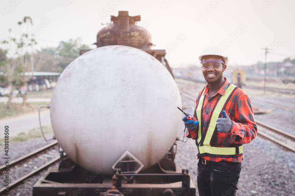 African male engineer control a the train on railway with talking by radio communication or walkie talkie