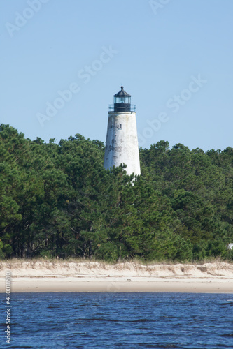 Lighthouse on the shore with trees