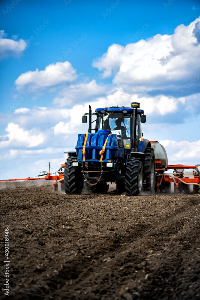 sowing work in the field. Tractor with seeder sowing work in the field. Tractor with seeder