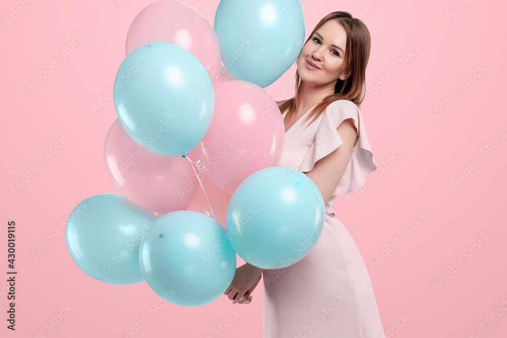 Beautiful young girl with with blue and pink balloons on the background, Joyful model. Happiness, spring, birthday party.