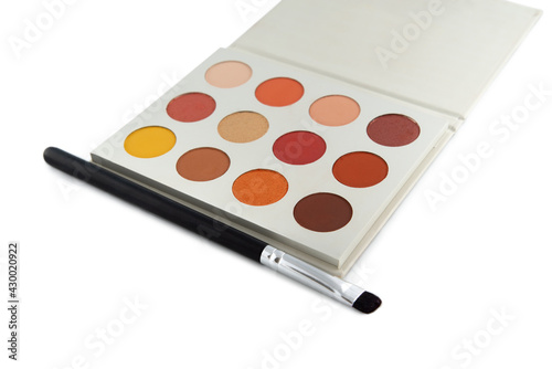 Red colored eye shadow palette and makeup brush