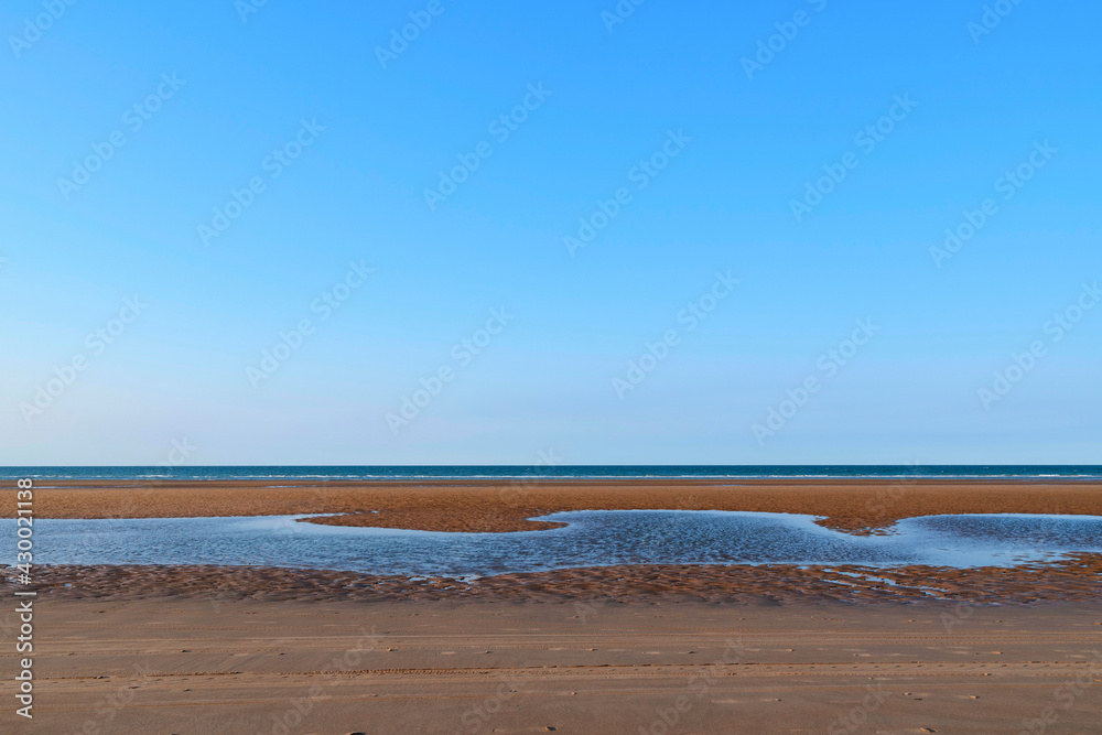 La plage de sable de Omaha beach au coucher de Soleil en France, en Normandie, dans le Calvados, au bord de la Manche. La plage de sable de Omaha beach au coucher de Soleil en France, en Normandie, dans le Calvados, au bord de la Manche.