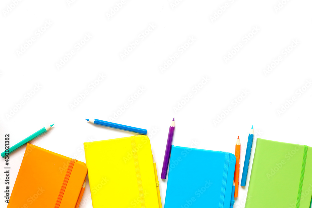 bright notepads in yellow, orange, green and blue colors, workplace background for designers with place for text. Color swatches palette, notebook, pencils for creative people and students. bright notepads in yellow, orange, green and blue colors, workplace background for designers with place for text. Color swatches palette, notebook, pencils for creative people and students.