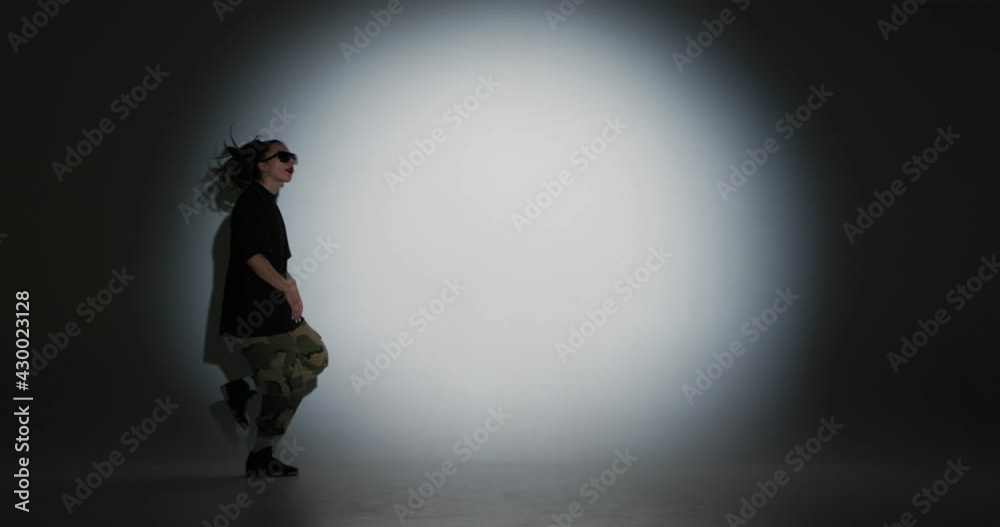 Dancing young girl cool moving to music in spotlight and leaves stage. Contemporary dance, hip-hop, rap youth culture Dancing young girl cool moving to music in spotlight and leaves stage. Contemporary dance, hip-hop, rap youth culture