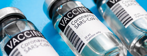 Coronavirus vaccine vials, banner panoramic photo, covid-19 vaccination background