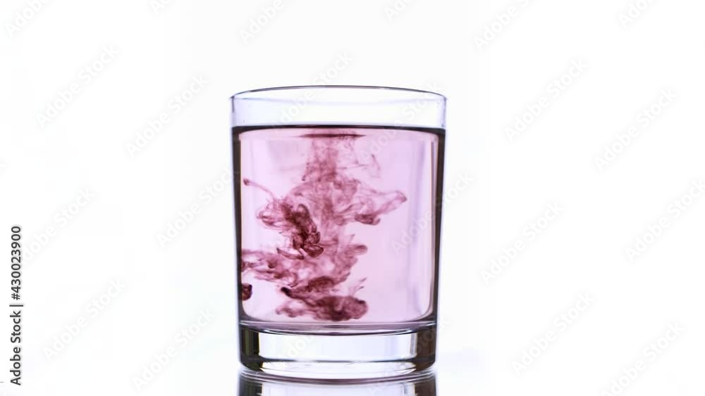Fall of a several bloody red ink drops into glass with rose colored water and then it mixed, breaking blending patterns in water until it becomes homogeneous solution, with increased concentration Fall of a several bloody red ink drops into glass with rose colored water and then it mixed, breaking blending patterns in water until it becomes homogeneous solution, with increased concentration