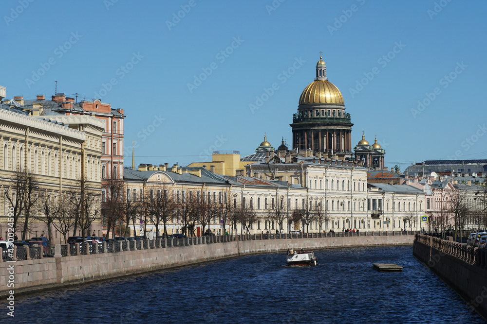 View of the Moika River, its embankment and the dome of St. Isaac's Cathedral in St. Petersburg in clear weather in spring.