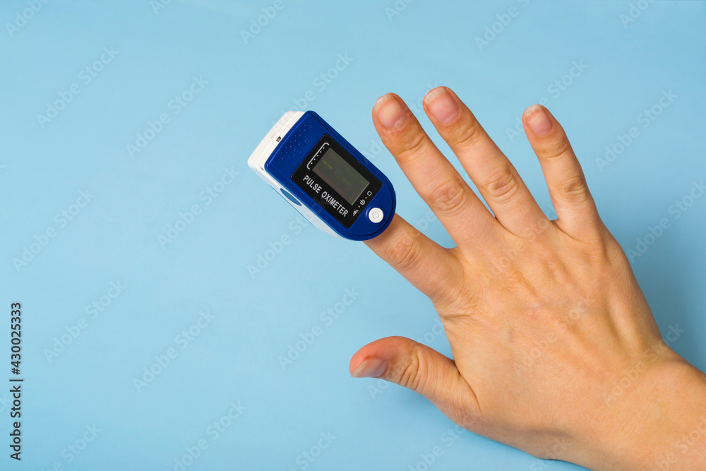 A pulse oximeter is on the woman's hand. A pulse oximeter used to