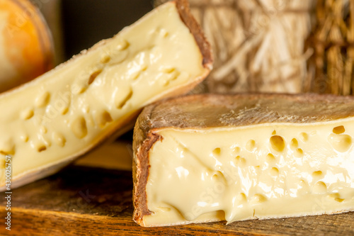 French cheese Saint Nectaire rustic collection delicious. Black background. photo