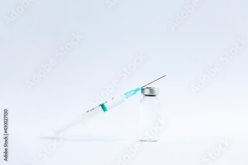 The vaccines vials glass bottle and disposable syringe on white photo