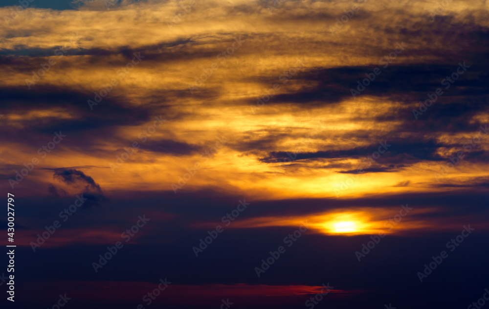 beautiful sunset sky, bright sun and dark silhouette of clouds as a background beautiful sunset sky, bright sun and dark silhouette of clouds as a background