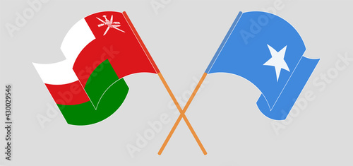 Crossed and waving flags of Oman and Somalia