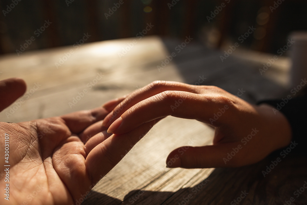 Hugging Hands of Lovers on Wooden Table in Sunny Day