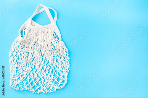 Mesh bag on blue background, zero waste or plastic free concept, horizontal, top view, copy space